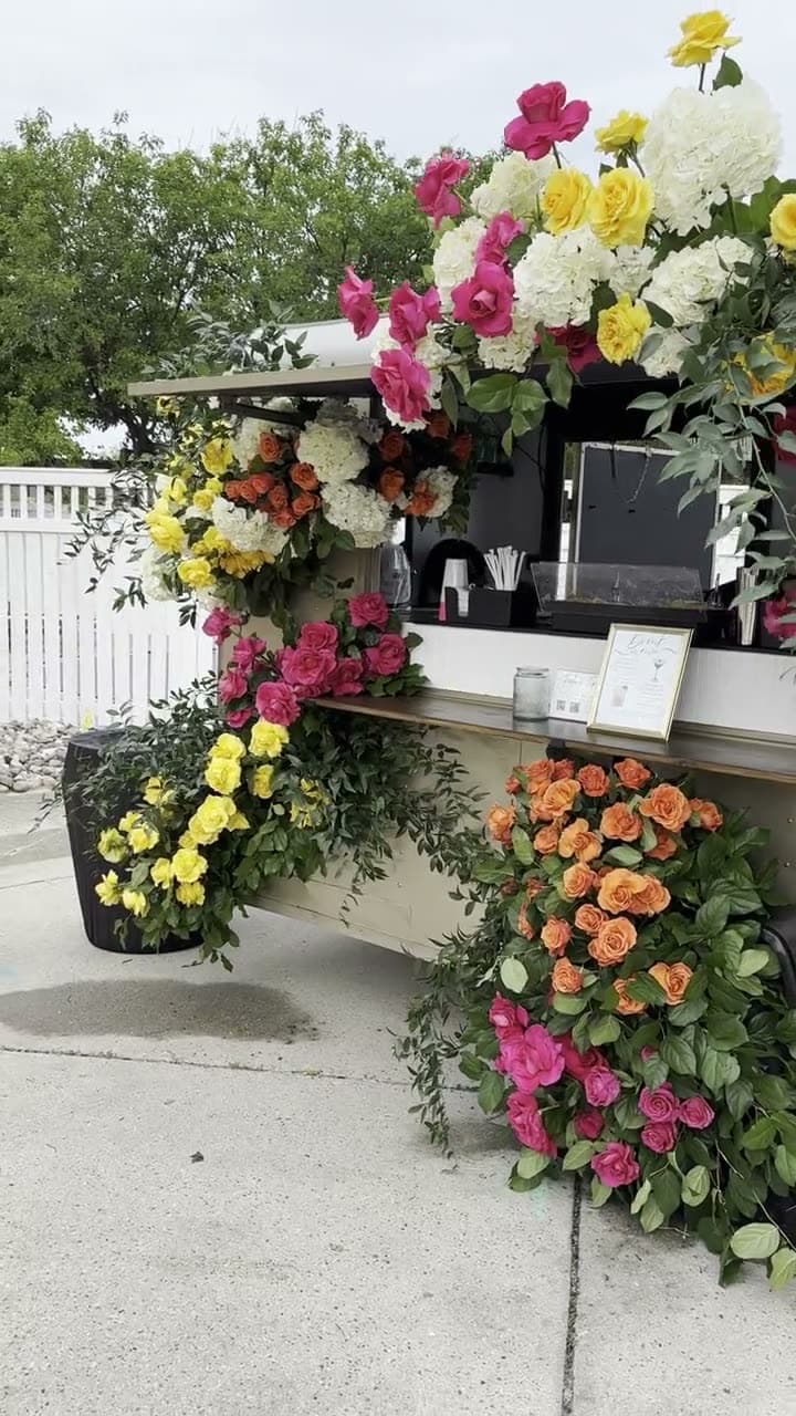 The Blair covered in pink, yellow, white and orange roses.