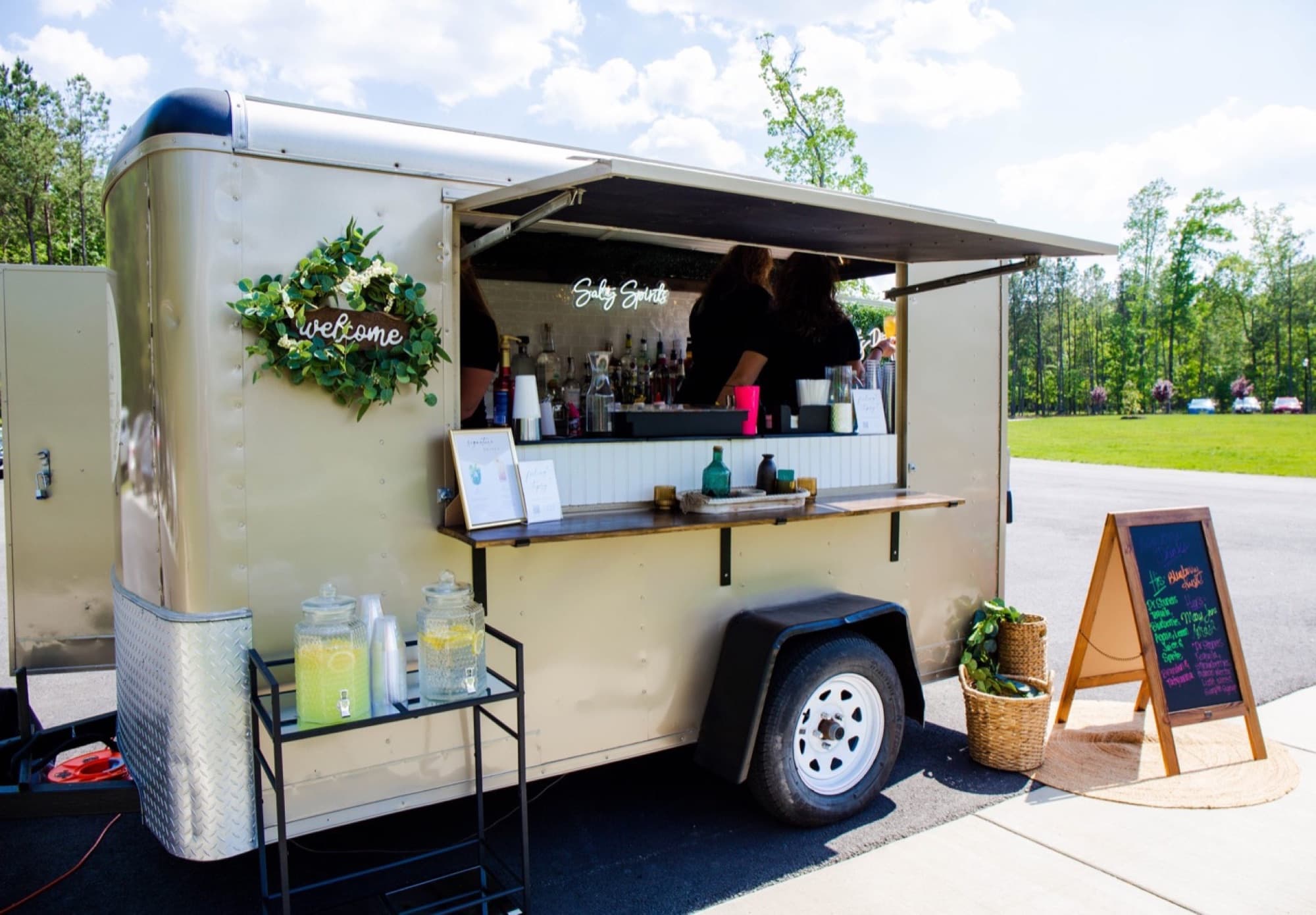 The Blair set up with its welcome wreath, lemonade dispensers and a chalkboard menu under a bright sky.