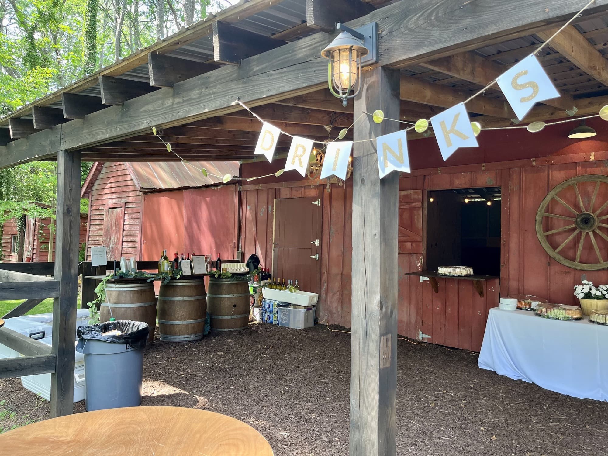The Pop Up Bar under a covered barn pavilion with a pennant banner, at a charming venue.